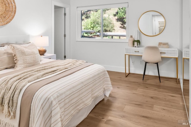 bedroom with baseboards and wood finished floors
