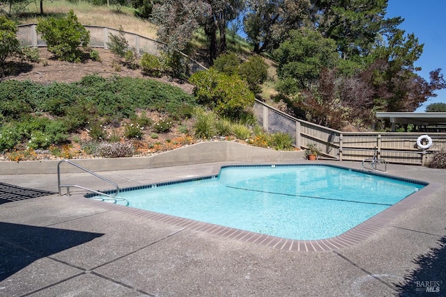 view of swimming pool featuring a patio area, fence, and a fenced in pool