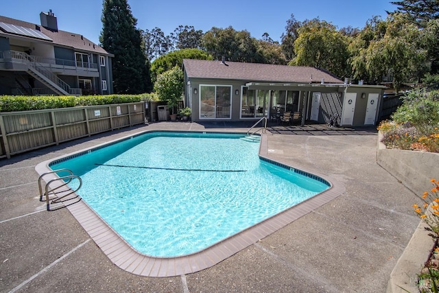 pool featuring fence and a patio