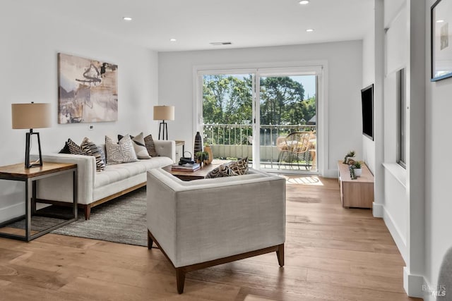 living room featuring recessed lighting, light wood finished floors, and visible vents