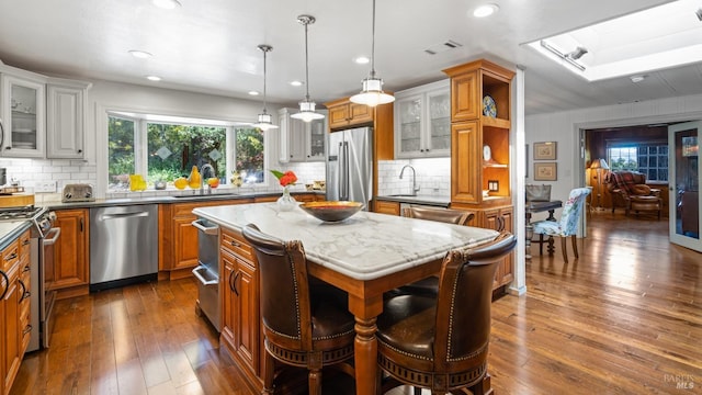 2267 Westside Rd, Healdsburg, CA 95448 - kitchen featuring stainless steel appliances, a skylight, brown cabinetry, a center island, and dark wood-style floors