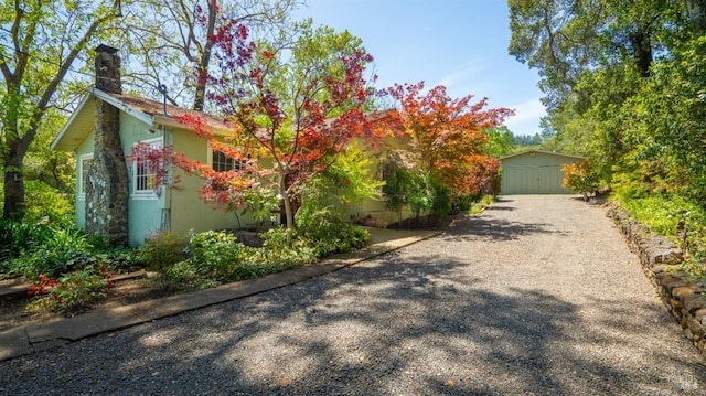 2267 Westside Rd, Healdsburg, CA 95448 - view of front facade featuring a chimney, an outdoor structure, driveway, and stucco siding