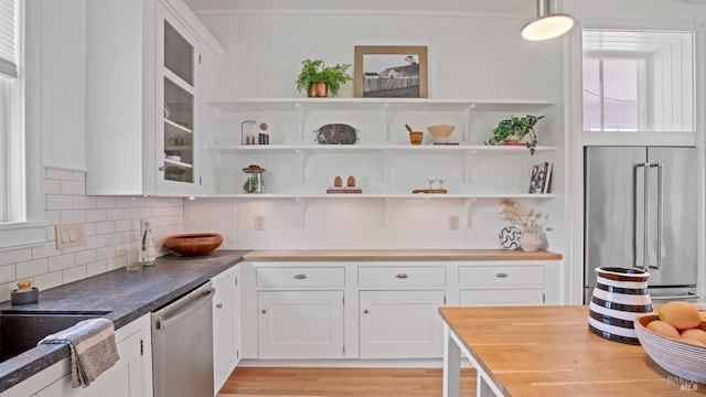 643 3rd St, Napa, CA 94559 - kitchen featuring glass insert cabinets, light wood finished floors, white cabinetry, decorative backsplash, and appliances with stainless steel finishes