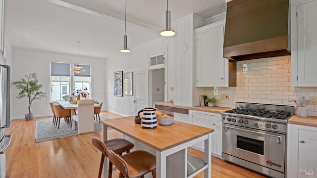 643 3rd St, Napa, CA 94559 - kitchen with wooden counters, custom exhaust hood, high end stainless steel range, backsplash, and white cabinets