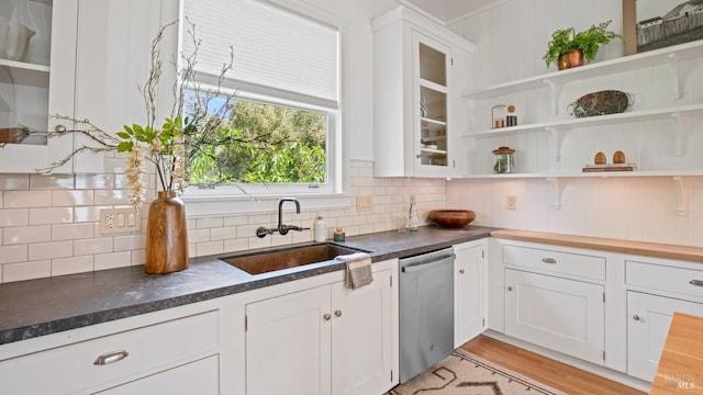 643 3rd St, Napa, CA 94559 - kitchen featuring stainless steel dishwasher, a sink, white cabinets, dark countertops, and tasteful backsplash