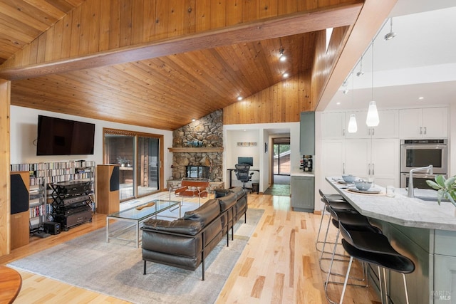 living room featuring a fireplace, light wood-style flooring, high vaulted ceiling, and wood ceiling