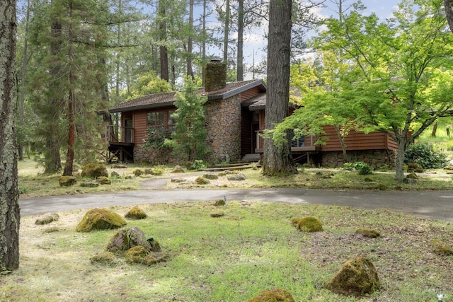 view of front of property with a chimney and stone siding