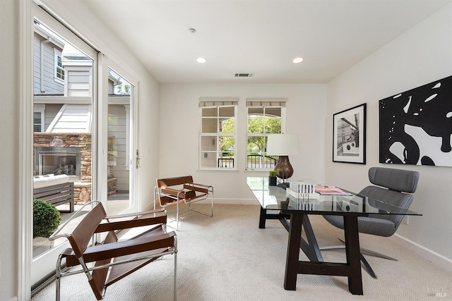 office space with carpet flooring, plenty of natural light, visible vents, and baseboards