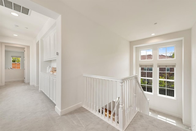 corridor featuring light colored carpet, visible vents, an upstairs landing, and recessed lighting