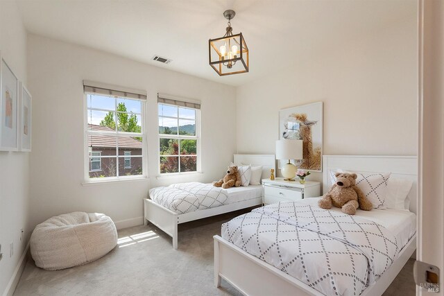 bedroom featuring a chandelier, light colored carpet, baseboards, and visible vents