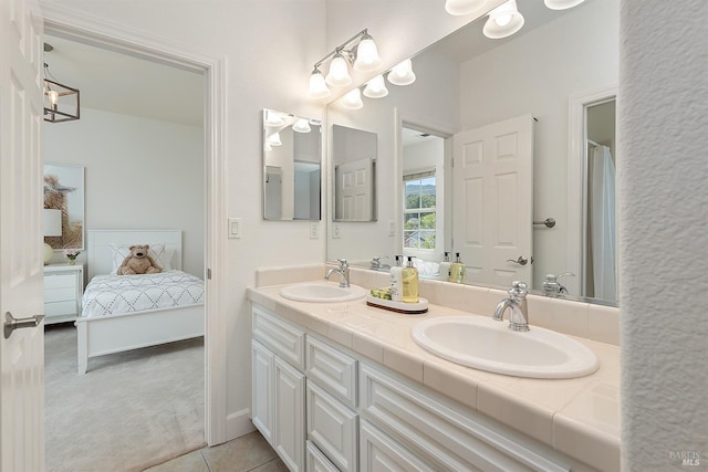 full bathroom with a sink, double vanity, ensuite bathroom, and tile patterned flooring