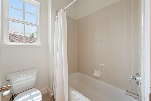 full bath featuring toilet, baseboards, and shower / bathtub combination with curtain