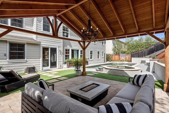 view of patio / terrace featuring an outdoor living space with a fire pit, an in ground hot tub, a fenced backyard, and a fenced in pool