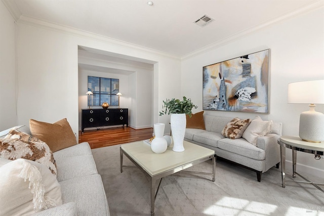 living room with baseboards, ornamental molding, visible vents, and wood finished floors