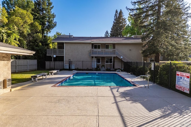 community pool with fence and a patio