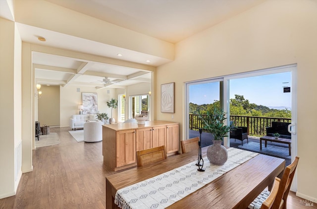 dining room with coffered ceiling, wood finished floors, baseboards, and beam ceiling