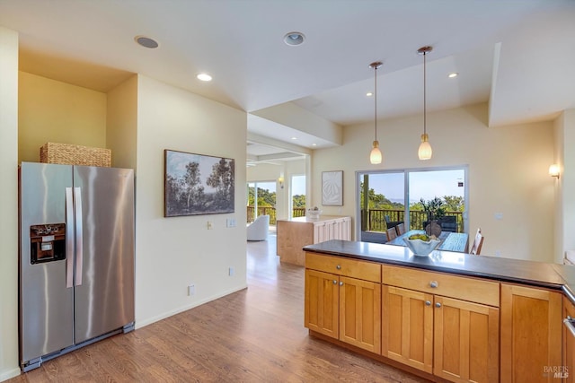 kitchen with recessed lighting, decorative light fixtures, light wood finished floors, a peninsula, and stainless steel fridge