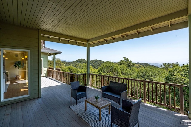 wooden deck featuring a view of trees, a mountain view, and outdoor lounge area