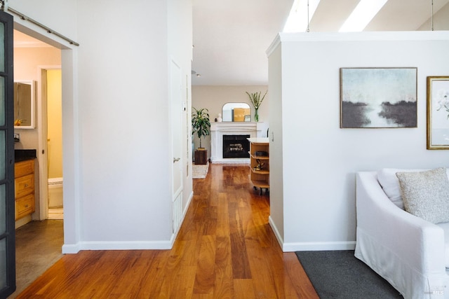 hall featuring wood finished floors and baseboards