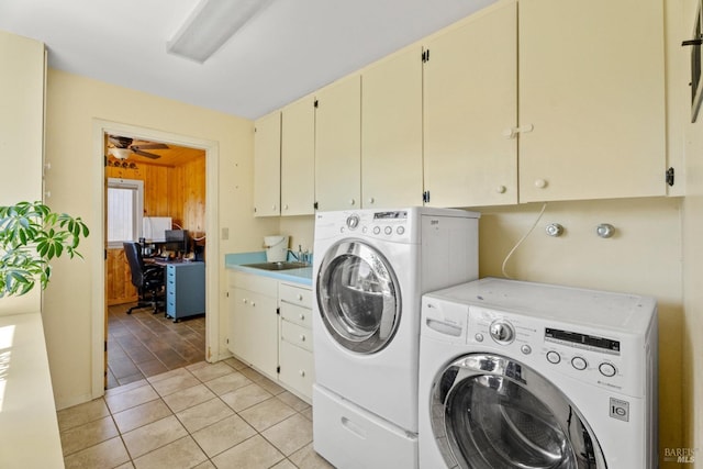 washroom featuring a ceiling fan, light tile patterned floors, a sink, washer and clothes dryer, and cabinet space