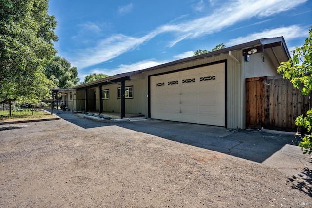 view of front of house with driveway, fence, and a garage