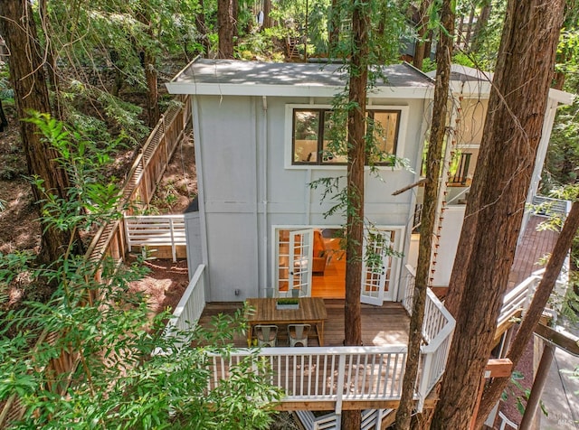 view of outdoor structure with french doors and fence