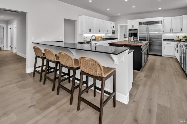 40 Los Pinos, Nicasio, CA 94946 - kitchen with butcher block countertops, light wood-style flooring, a breakfast bar area, visible vents, and stainless steel appliances