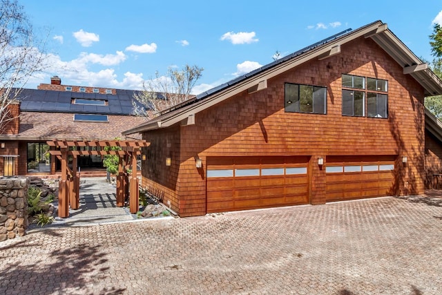 40 Los Pinos, Nicasio, CA 94946 - chalet / cabin featuring an attached garage, a pergola, a shingled roof, decorative driveway, and solar panels