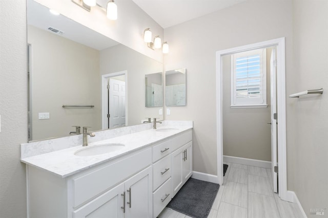 full bathroom featuring baseboards, visible vents, a sink, and double vanity