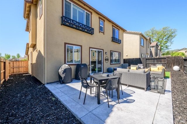 back of house with stucco siding, a fenced backyard, and an outdoor living space