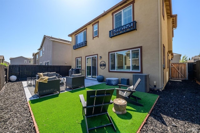back of property featuring a gate, stucco siding, a fenced backyard, central AC unit, and outdoor lounge area