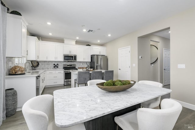 dining space featuring visible vents, wood finished floors, baseboards, and recessed lighting