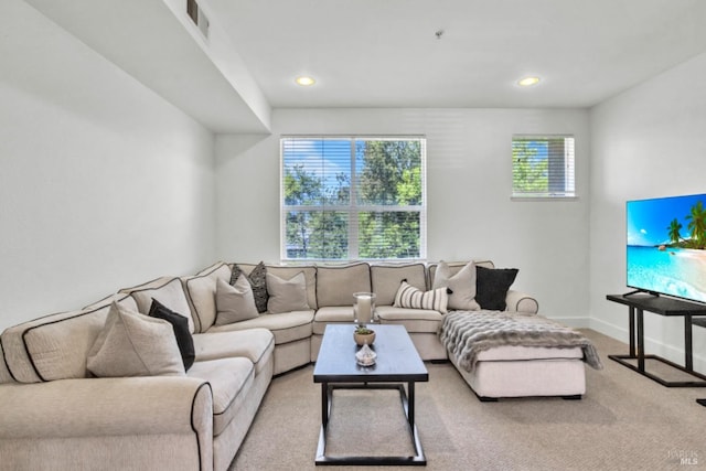 carpeted living area featuring baseboards, visible vents, and recessed lighting