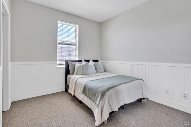 bedroom with wainscoting and carpet floors