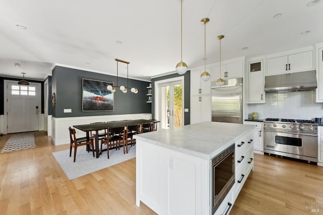 11 Heather Way, Larkspur, CA 94939 - kitchen with under cabinet range hood, built in appliances, healthy amount of natural light, white cabinetry, and wainscoting
