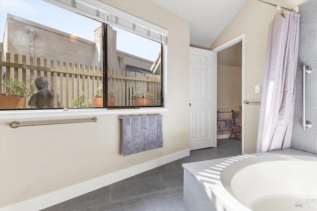 822 2nd St W, Sonoma, CA 95476 - bathroom with baseboards, tile patterned flooring, a bathtub, and vaulted ceiling