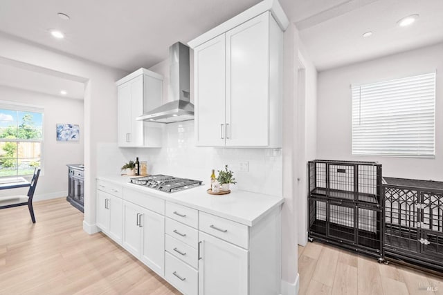 1532 Base Ct, Dixon, CA 95620 - kitchen featuring wall chimney range hood, tasteful backsplash, stainless steel gas stovetop, light countertops, and light wood-style floors