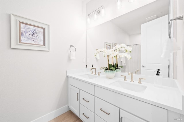 1532 Base Ct, Dixon, CA 95620 - bathroom featuring baseboards, double vanity, a sink, and wood finished floors