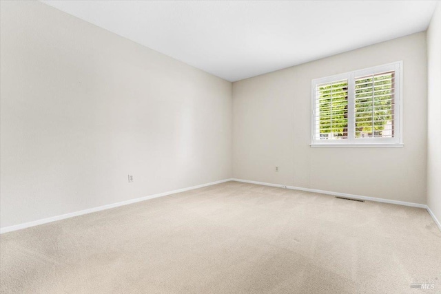 unfurnished room featuring baseboards, visible vents, and light colored carpet