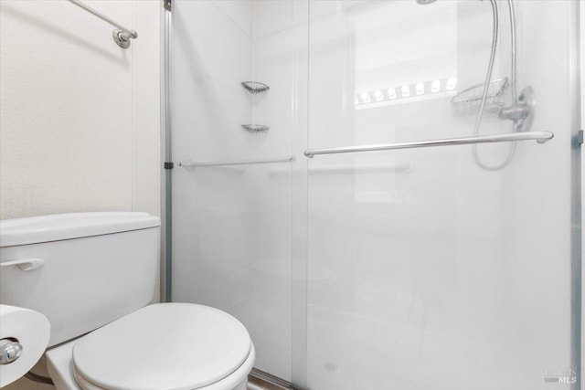 full bath featuring toilet and a shower stall