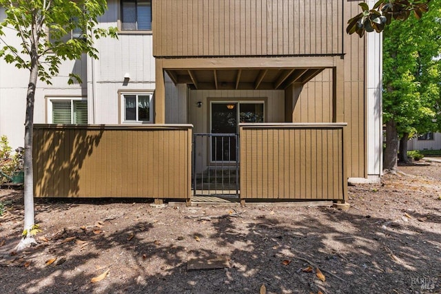 back of house featuring fence and a gate