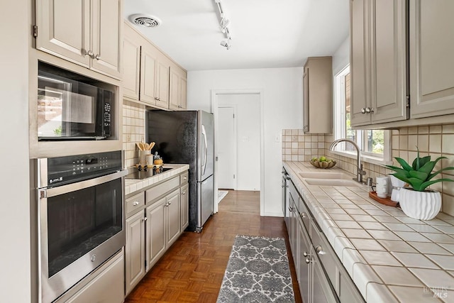 15 Junipero Serra Ave, San Rafael, CA 94901 - kitchen with tile countertops, black appliances, a sink, tasteful backsplash, and track lighting