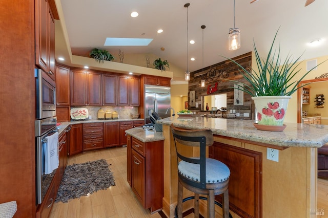kitchen featuring light wood-type flooring, built in appliances, lofted ceiling with skylight, and backsplash