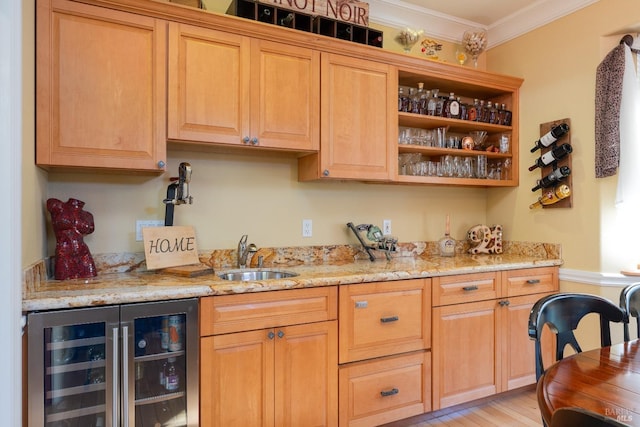bar featuring a sink, wine cooler, ornamental molding, wet bar, and light wood-style flooring