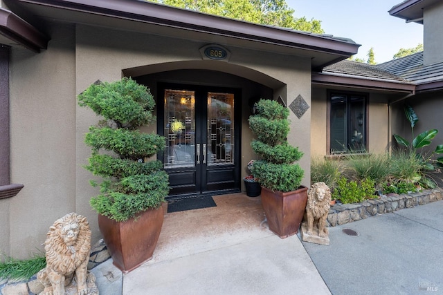 property entrance with stucco siding and french doors