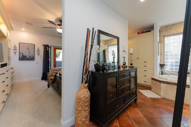 hall with baseboards, dark tile patterned flooring, recessed lighting, and plenty of natural light