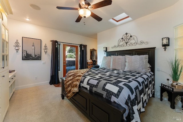 bedroom with a skylight, light carpet, baseboards, and a ceiling fan