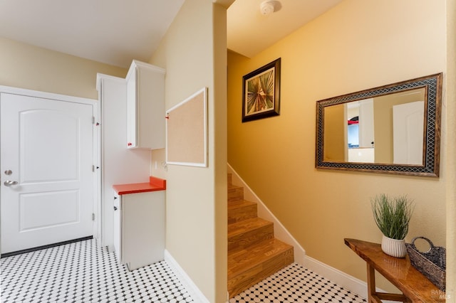 stairs with tile patterned floors and baseboards