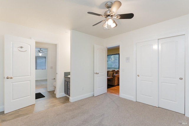 unfurnished bedroom with baseboards, a closet, a ceiling fan, and light colored carpet