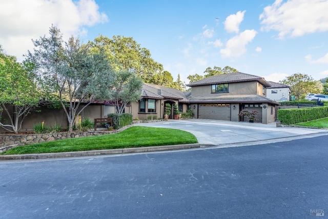 traditional-style house featuring an attached garage, stucco siding, and driveway